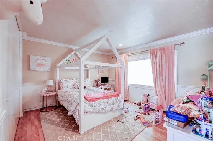 Light and bright secondary bedroom with wainscoting.