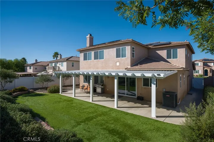 Rear yard with planters, artificial turf and a covered patio