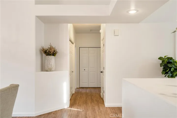 Hallway to the right when facing dining. Leads to primary bedroom, garage entrance and laundry.