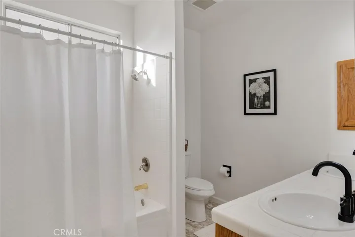 Hall bathroom with shower/tub combo. New fixtures in shower/bath.