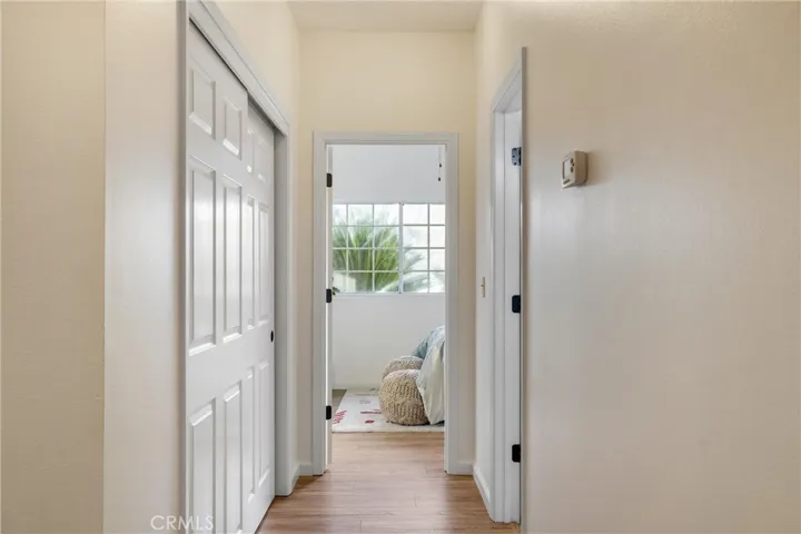 Hallway opposite side of house from primary bedroom. Storage closet on the left. Full bathroom on the right. Bedroom 3 directly ahead. Bedroom 2 directly behind where the photographer was standing.