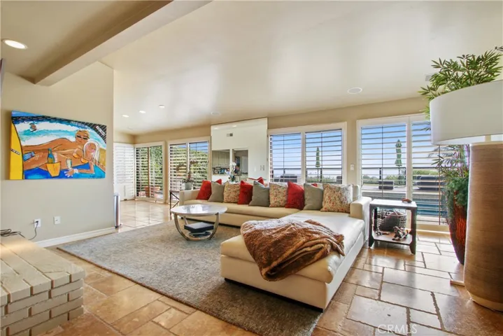 Open floor plan livingroom with double sided fireplace, and multiple sliding doors to outdoors.