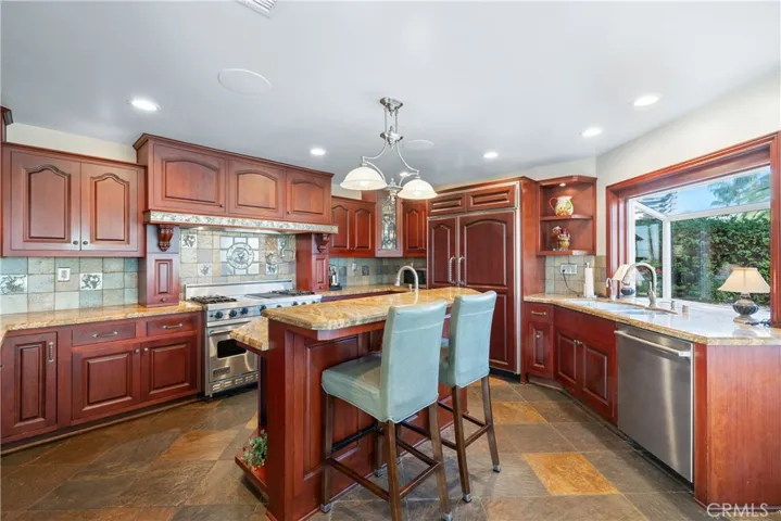 Kitchen with island view, Viking range with griddle and grill, and pot filler on the backsplash.