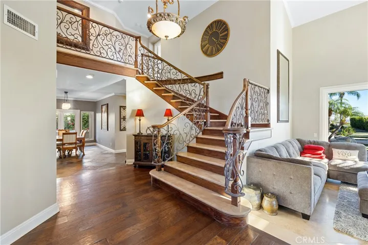Sweeping staircase with iron and wood handrail/banister with travertine slab steps.