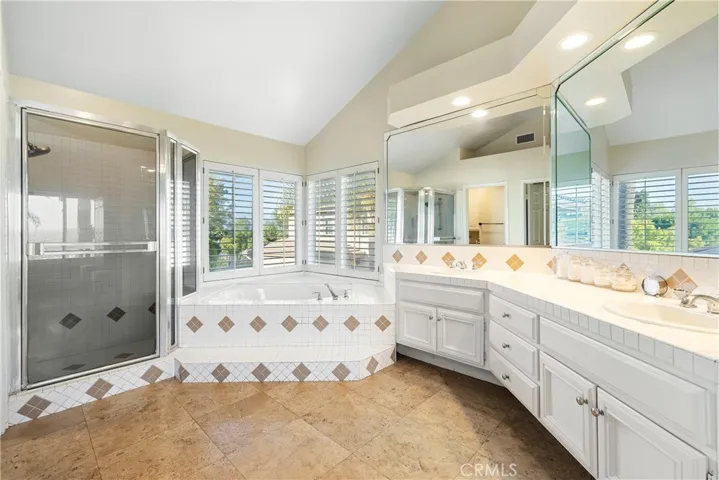 Primary bathroom with a walk-in shower, separate tub, dual sinks, and a walk-in closet not pictured.