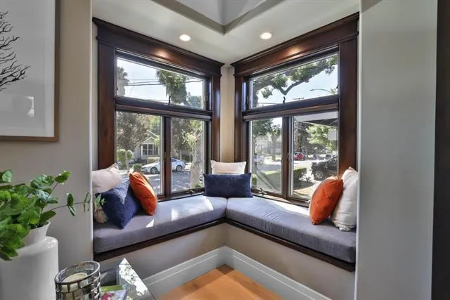 Corner window seat with custom cushions and cedar-lined storage trunks below