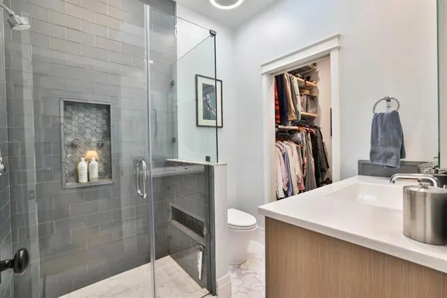 High-end, Toto toilet; chrome fixtures; lighted mirror/cabinet; glass tiles; sleek, frameless shower