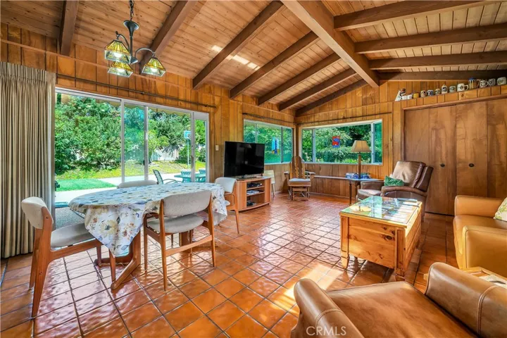 The den with laarge windows which  accommodate social gatherings or merely viewing the outdoor activities. large windows and entrance to the back yard