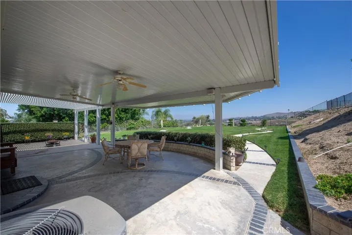 The large patio is partially covered with a solid aluminum cover.