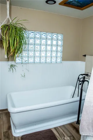 Master/primary free standing tub.  Bathroom also includes dual vanities, custom tile backsplash, wood grain tile floors, free standing tub and separate shower.