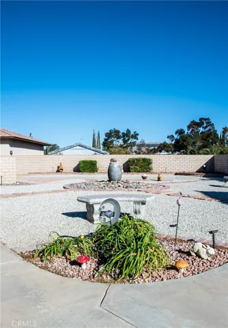 Rear yard showing low maintenance landscaping and block wall.