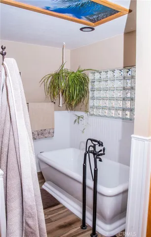Master/primary free standing tub.  Bathroom also includes dual vanities, custom tile backsplash, wood grain tile floors, free standing tub and separate shower.