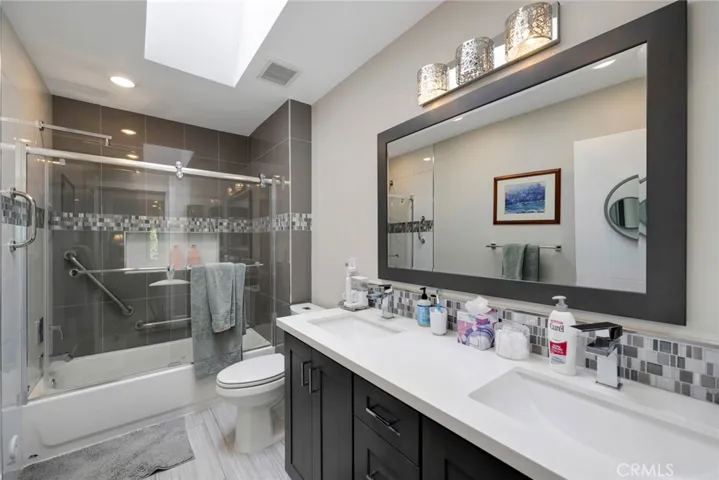 Primary En Suite with Dual Sinks, Quartz Countertops, Tub/Shower Combo, Tile Flooring, and Skylight!