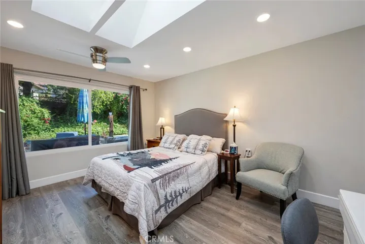 Primary Suite has Ceiling Fan/Light, LVT Flooring, Skylight with Built-in Shades, and Large Window with Views!
