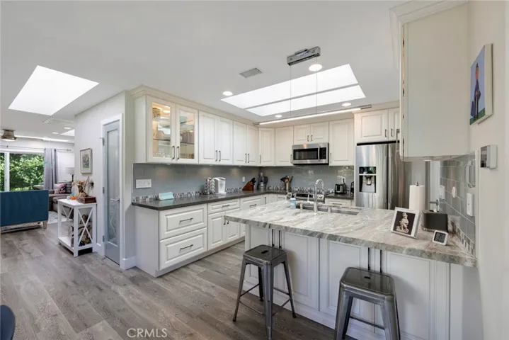 FULLY Remodeled Kitchen with White Cabinetry, Quartz Countertops, Skylight, Stainless Steel Appliances, and TONS of Storage.