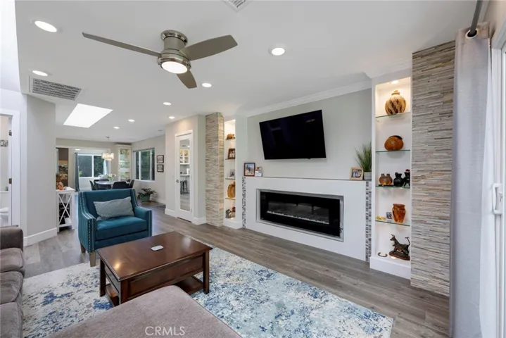 Stunning Fireplace with Custom Shelving Surround, Crown Moulding, and Recessed Lighting!