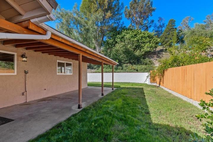 Lush hillside landscaping with open space behind the lot provides significant privacy.
