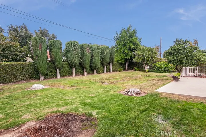 The expansive backyard will be a favorite entertainment destination with its lush green lawn, well-trimmed hedges, mature shade/citrus trees, open patio, and a fenced and gated open brick patio.