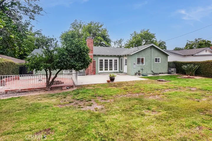 The expansive backyard will be a favorite entertainment destination with its lush green lawn, well-trimmed hedges, mature shade/citrus trees, open patio, and a fenced and gated open brick patio.