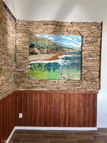 .Colorful custom tile mural with stacked stone trim.