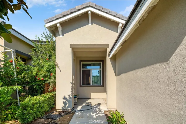 trail walk to front entrance of home with small porch/patio.