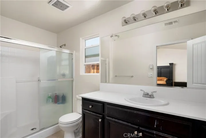 Master bathroom with walk in closet in bathroom on right side & walk in shower.