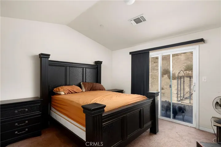 Master bedroom with sliding doors to backyard. Carpeted.