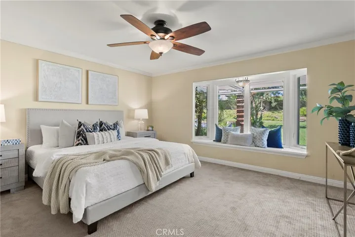 The spacious primary suite with a bay window to the backyard.
