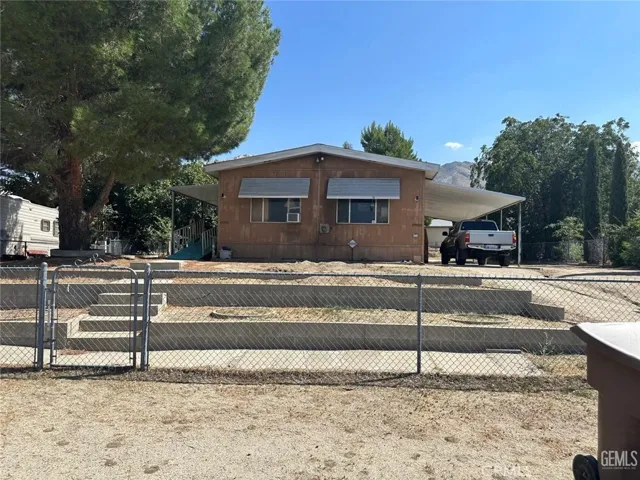 Spacious double-wide mobile home on its own supersized lot with covered carport and detached garage. Big Patio deck with ramp for easy access.