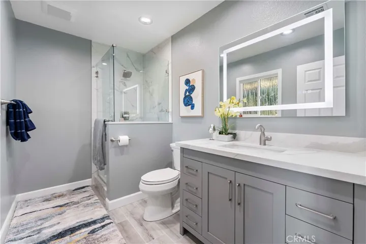 Lovely 3/4 bathroom off from family room with touch light at mirror. Not shown is a lovely bamboo glass window for privacy while allowing natural light to come through.