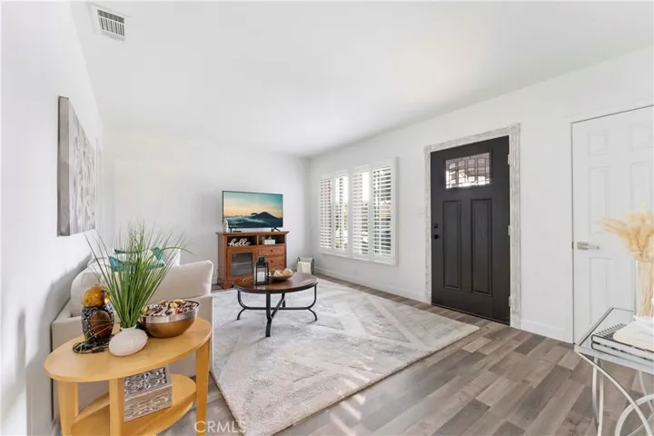 Formal living lovingly updated with luxury vinyl plank flooring and double pane windows and door/screen door and paint.