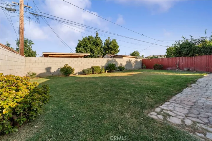 Spacious backyard with block walls. Wood fence at one side.