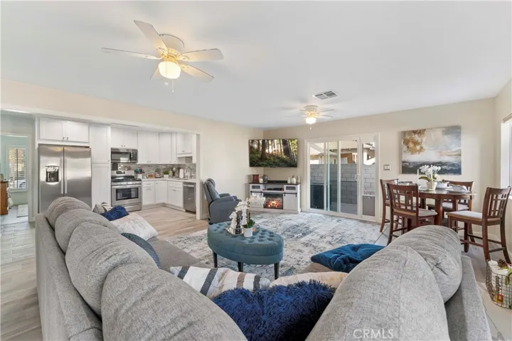Roomy area with ceiling fans and dining space. Sliders to concrete patio.