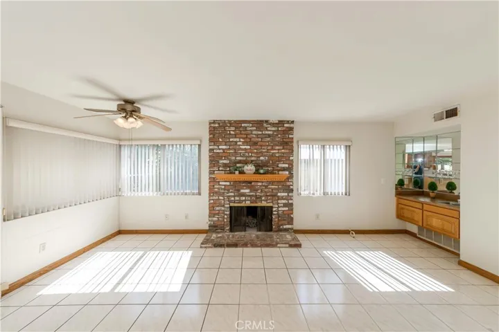 Great room feature cozy brick fireplace, ceiling fan and a wet bar.