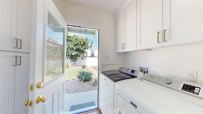 Laundry room with newer washer & dryer and cabinets for storage.