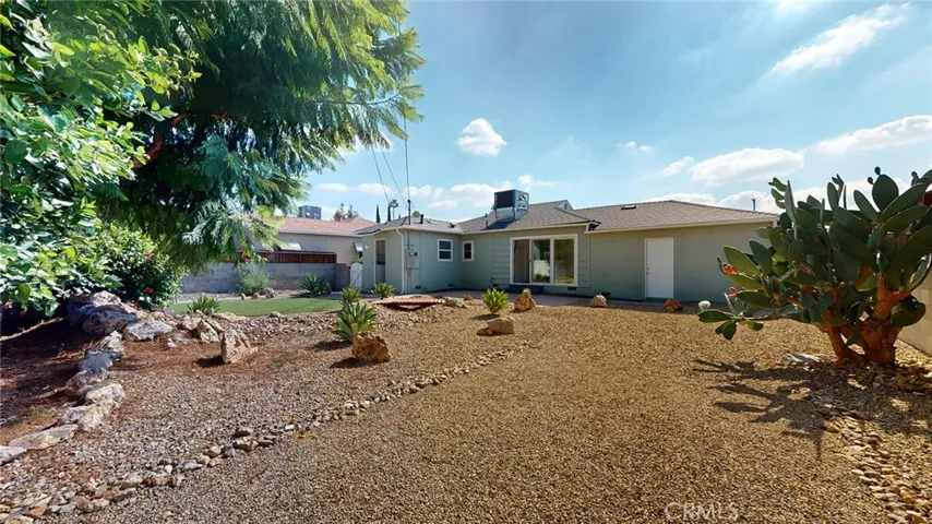 View of beautifully landscaped backyard from back corner facing house.