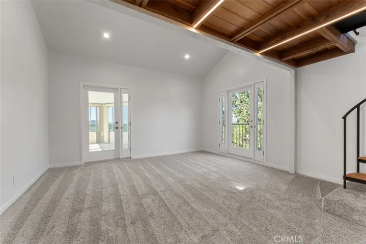 The primary suite features two French doors, one for office/view room access and one for the private balcony.