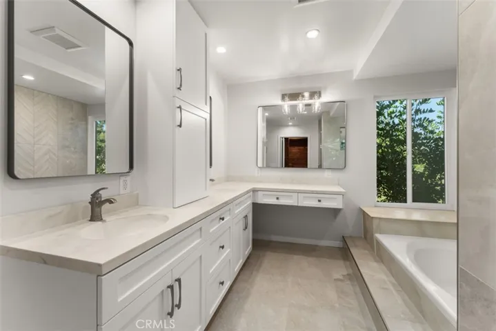 The primary suite bathroom features two skinks, vanity, and lots of storage.