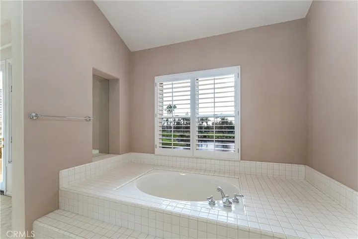Roman style soaking tub with golf, lake and sunset view