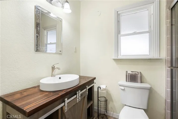 Second bathroom with tiled shower and new vanity.
