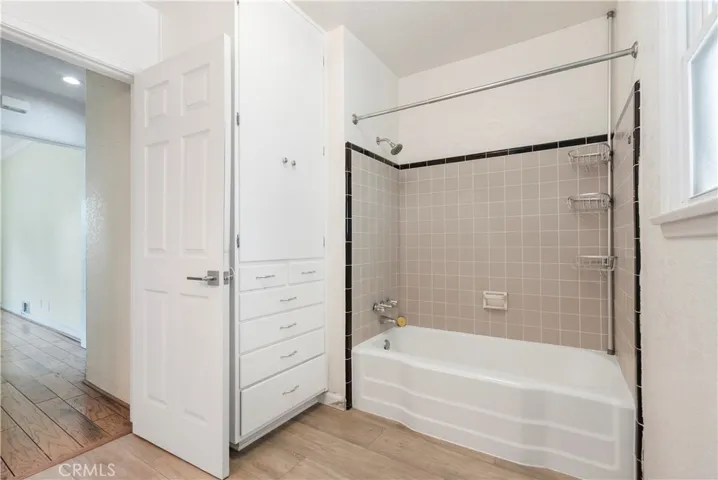 Shower in tub in the spacious hallway bathroom with plenty of cabinetry.