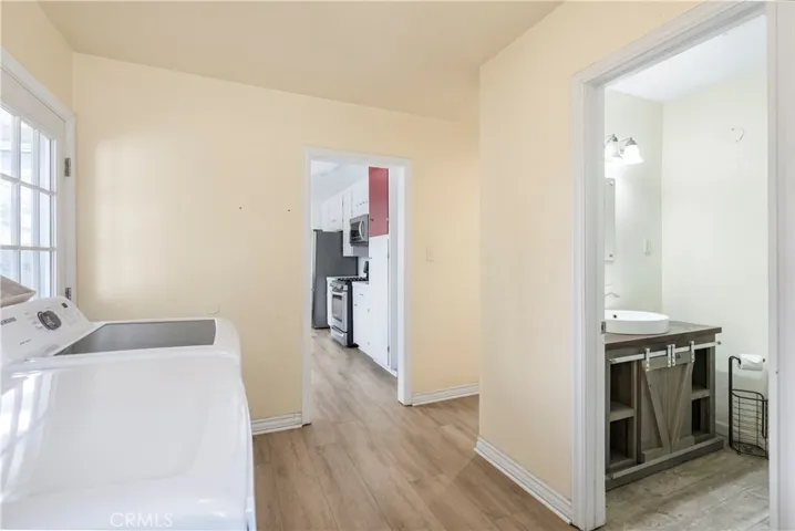Alternate view of the laundry room into the second bathroom and the kitchen.