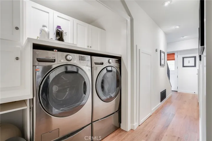 The laundry area includes abundant storage and an area to the left to accommodate pets (feeding station, kitty litter box, etc.). The door in the middle of the photo accesses under-stair storage.