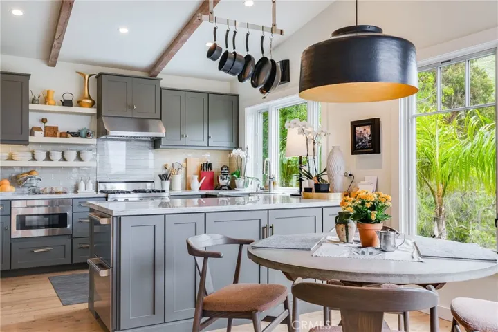 Kitchen, dining, and living room flow openly with an abundance of windows open to the view with light from dawn to dusk.
