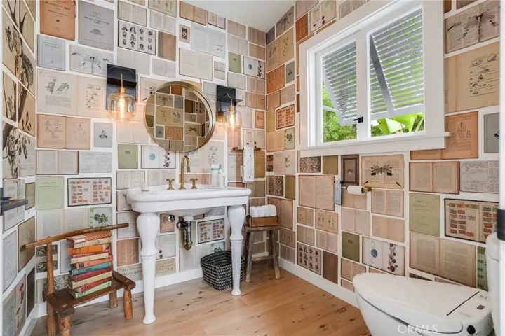 Art wall coverings and custom lighting sconces create a unique powder room vibe.