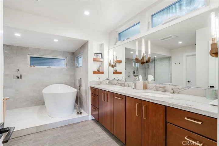 The large primary bath has dual sinks, a center pull-out for electric grooming items (hair dryer, trimmers, etc.), and plenty of storage. The wet room has a Bain Ultra tub, walk-in shower with heated and lit grooming mirror, and gorgeous small format marble tile flooring.