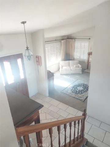 living room from top of stais...plantation shutters and entry