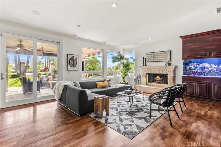 Family room with Fireplace, 400 gallon salt water fish tank and windows to the beautiful green backyard and the pool.
