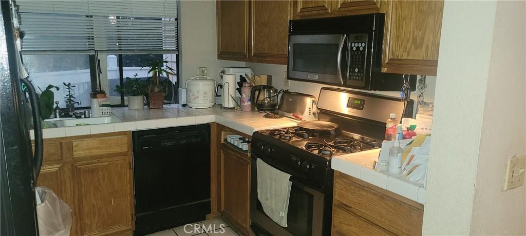 kitchen newer stove , dishwasher microve view of couryard