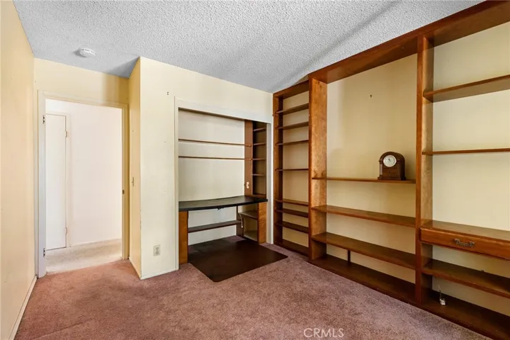 Bedroom with build in shelving and desk.